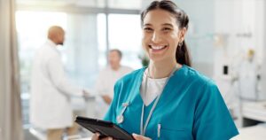 Smiling nurse holding a tablet in a medical clinic, ready to answer questions about abortion pills and pregnancy options.